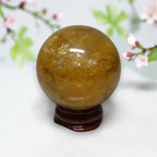 Polished Golden Healer Quartz ball on wood stand side view