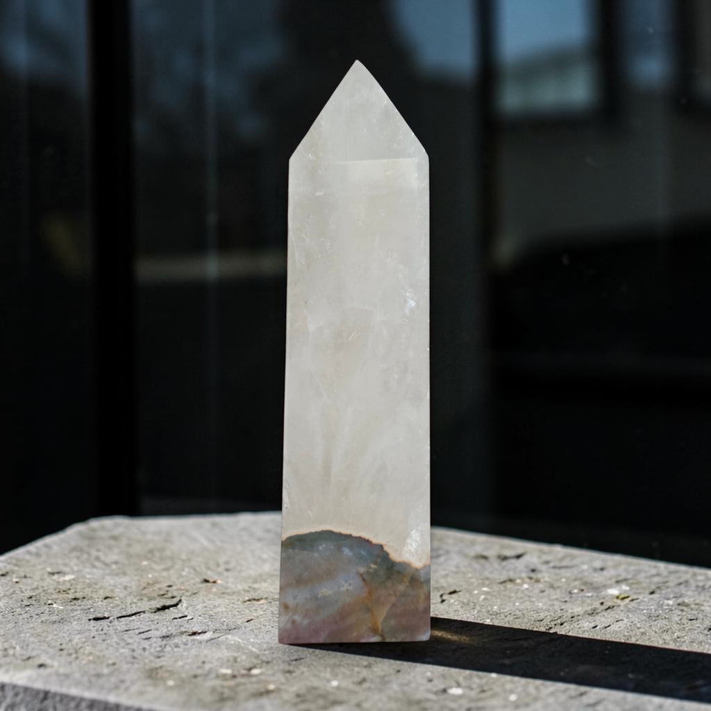 Quartz tower with Ocean Jasper base displayed beside pink flowers