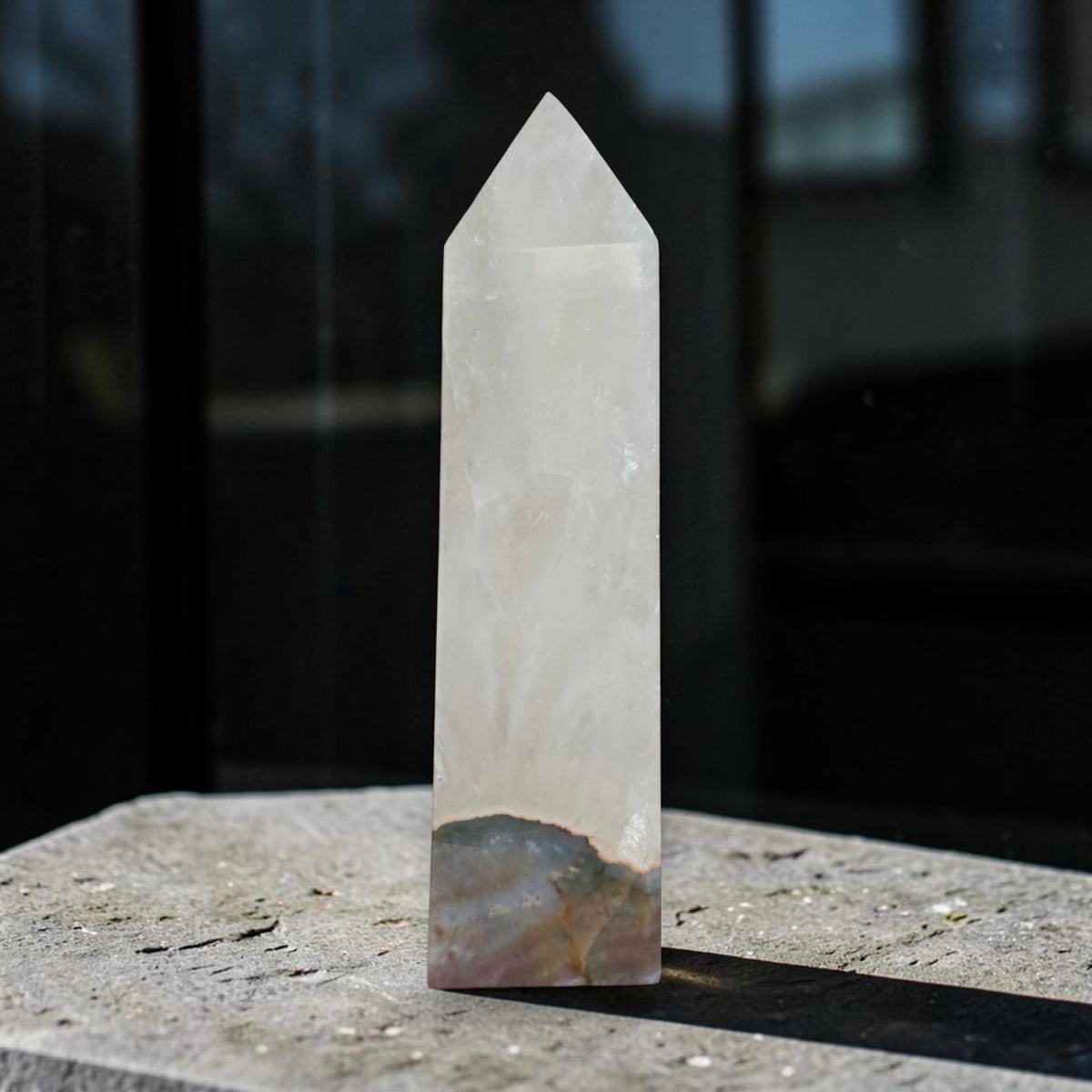 Quartz tower with Ocean Jasper base displayed beside pink flowers