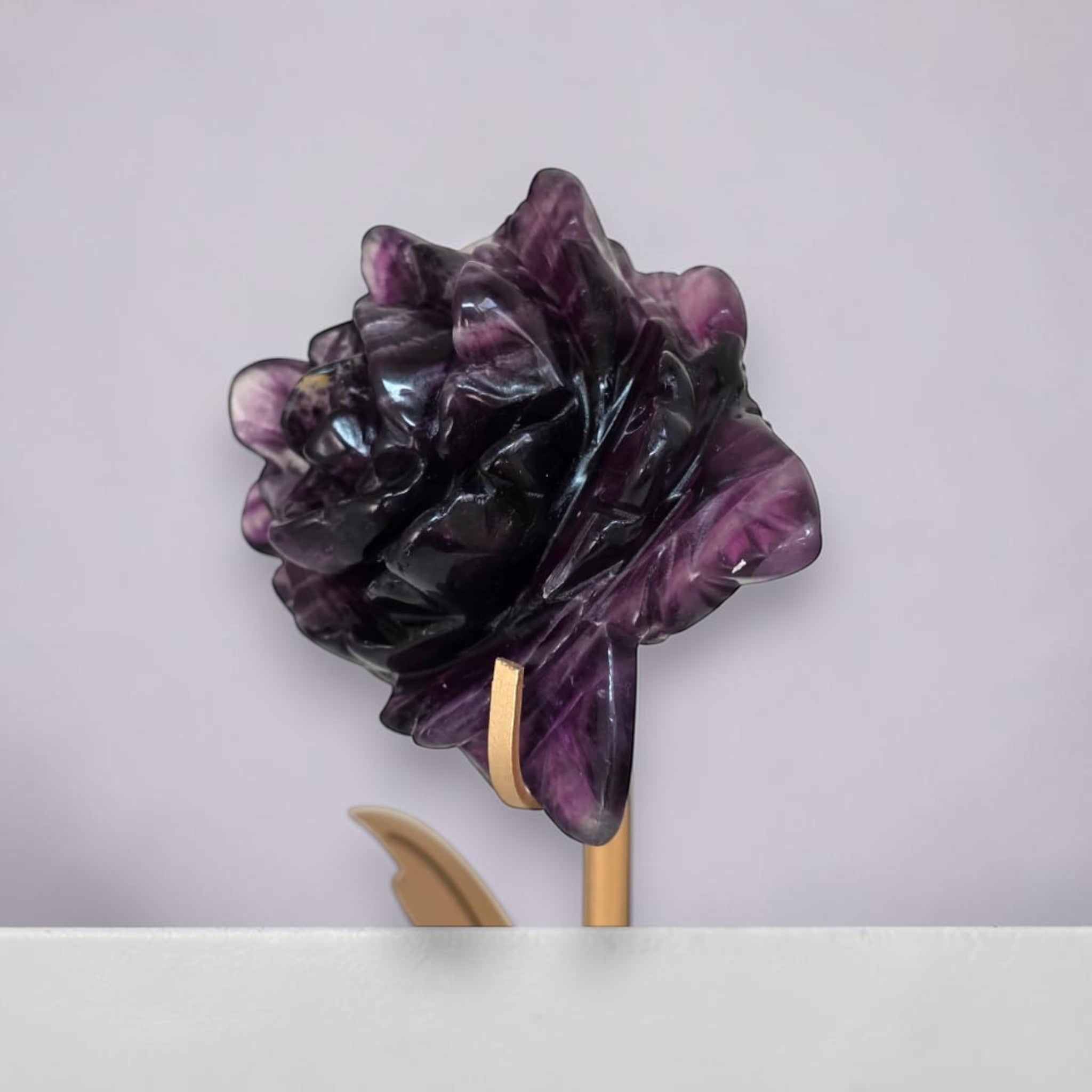 Purple fluorite rose carving on gold stand, side view