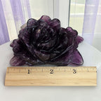 Purple fluorite rose carving with ruler showing approximately 3.5 inches wide