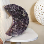 Purple speckled crescent moon crystal decor, side view on black metal stand