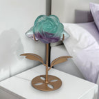 Rainbow fluorite rose on gold stand on bedroom nightstand