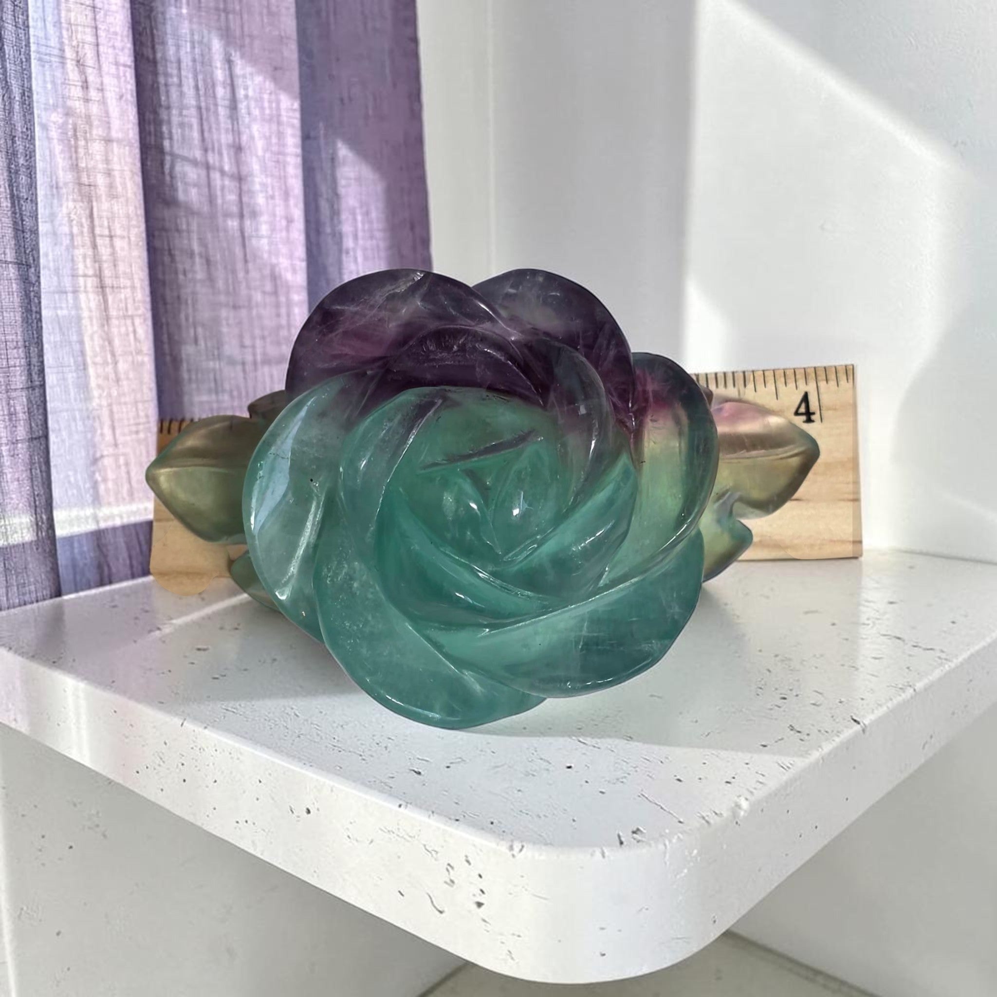 Rainbow fluorite rose carving on gold stand, front view, home decor