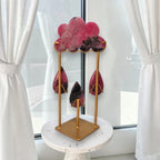 Rhodonite rain cloud crystal sculpture on gold stand with pink cloud and teardrops, on round base