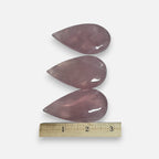 Rose quartz teardrop crystal pieces with ruler for size reference