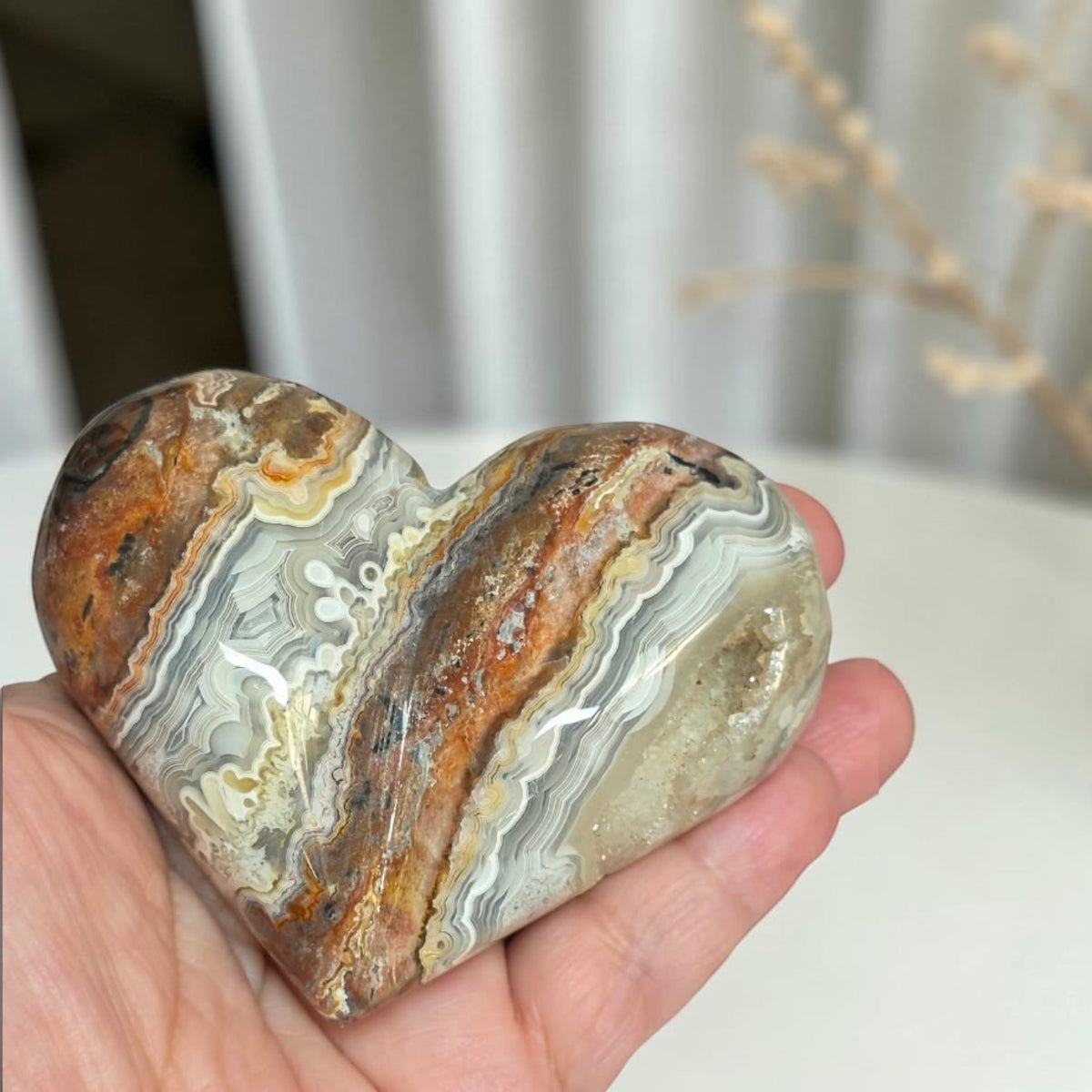 Mexican crazy lace agate heart with terracotta, brown, gray and white bands and a druzy corner