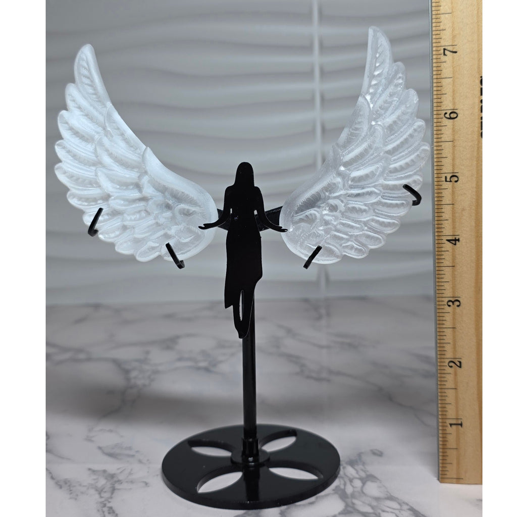 Selenite angel wings on stand beside ruler for scale
