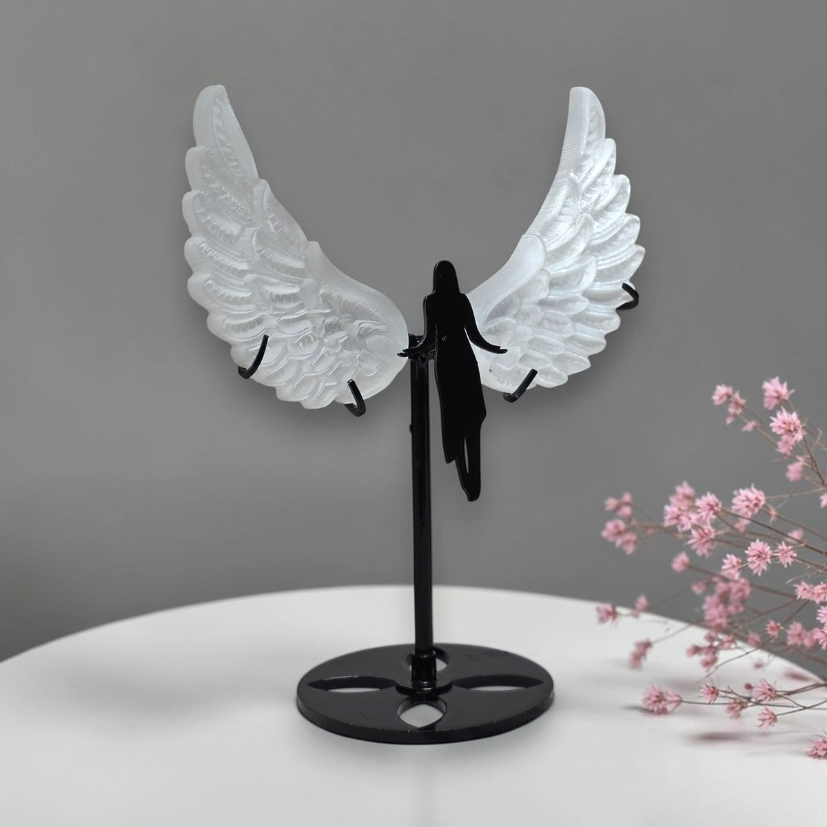 Front view of selenite angel wings on black stand