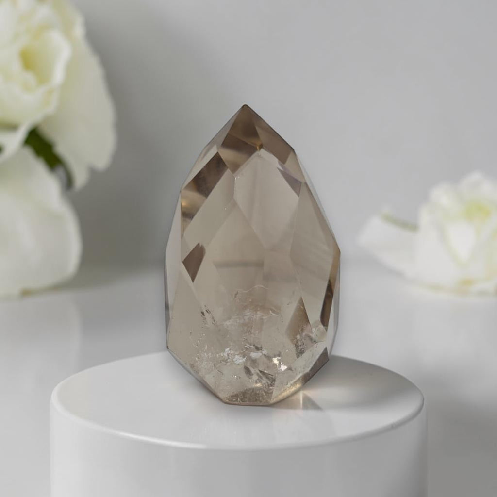 Smoky quartz faceted freeform on white round base, large cut crystal