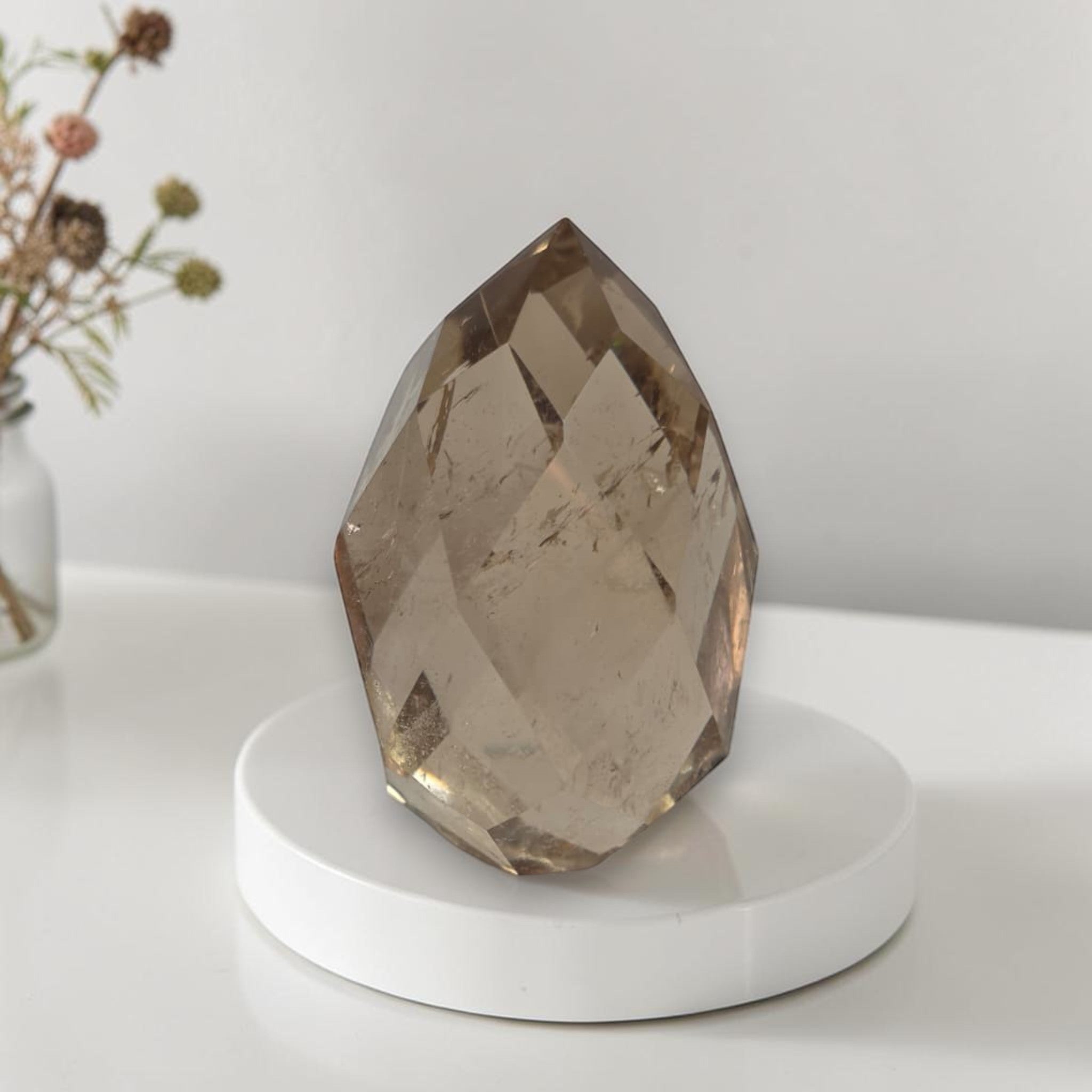 Smoky quartz faceted freeform on white round base, large faceted teardrop crystal