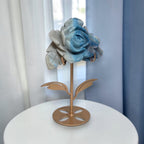 Natural Trolleite rose carving on gold flower stand displayed on white side table, front view