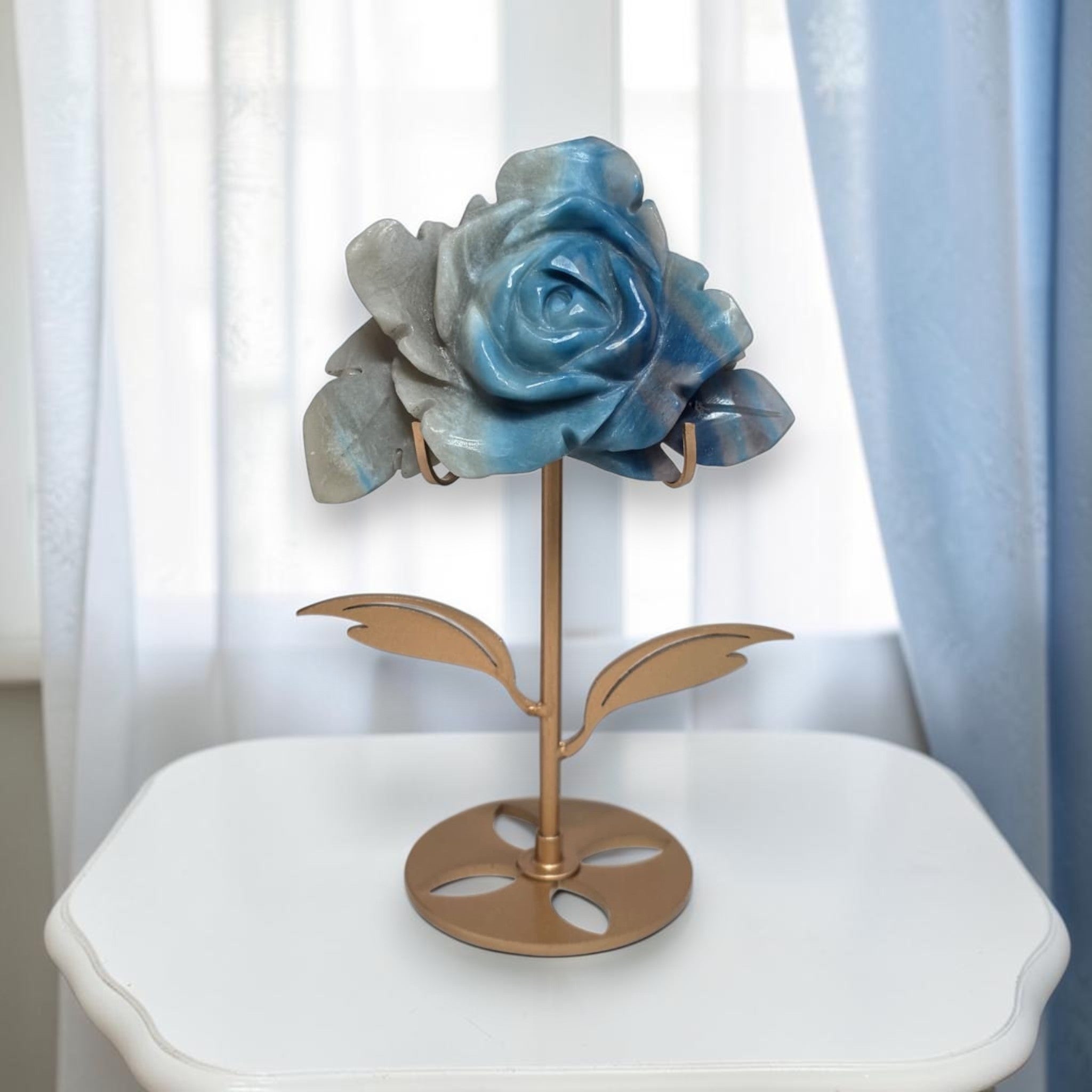 Natural Trolleite rose carving on gold stand, top-down view showing petal detail and indigo center