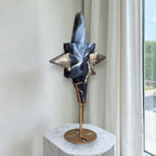North star crystal sculpture with blue and gray stone-like facets on a round bronze base.
