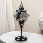 Star-shaped agate crystal carving on black metal stand, dark blue and gray facets