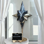 Blue, black, and smoky star crystal sculpture on a gold stand atop a marble-style base.