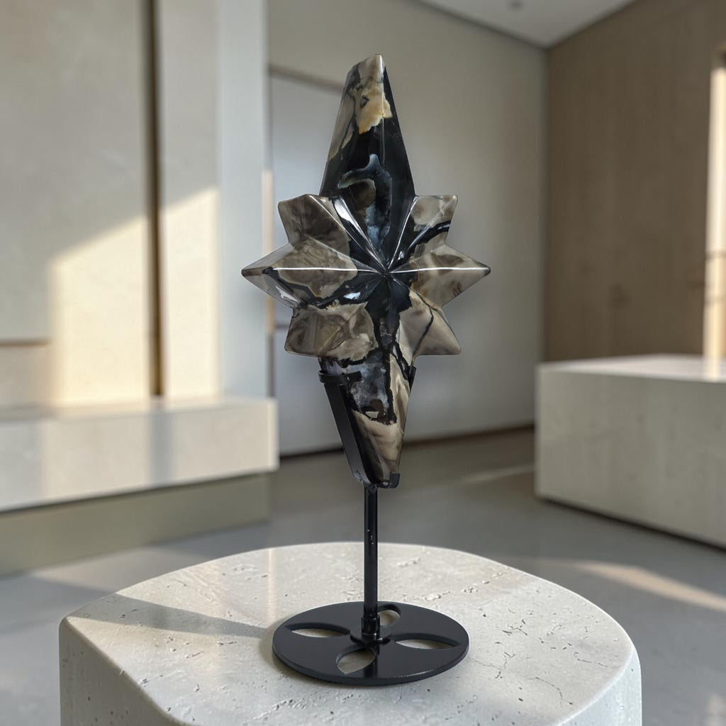 Polaris star crystal carving on round black base stand, dark blue and light stone