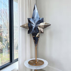 Star-shaped crystal sculpture with blue and dark facets standing on a round marble-style base.