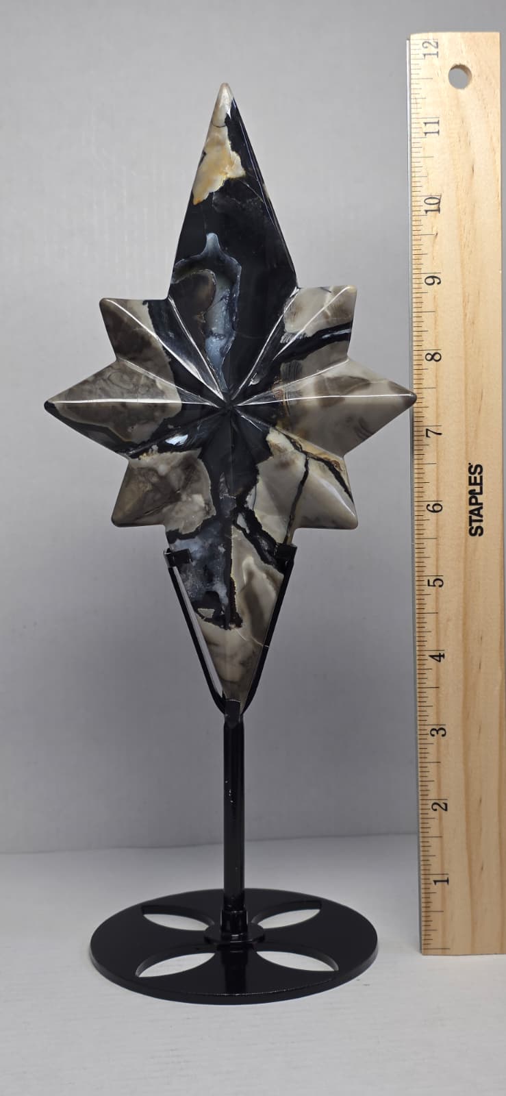 Polaris star crystal carving on black stand with height measurement, dark blue and cream