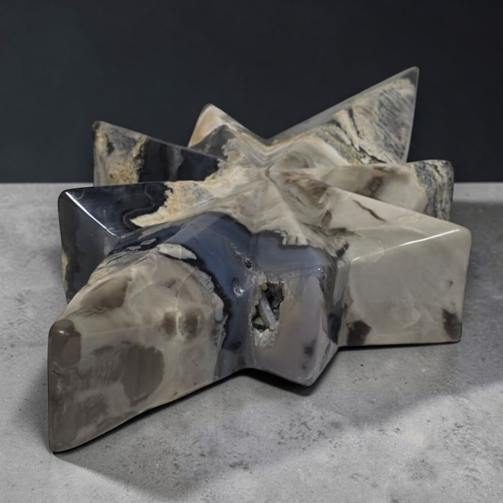 Facet agate star carving with layered white, gray, and dark blue tones on a base