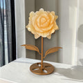 Yellow calcite rose carving on gold stand, front view, home decor