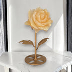 Yellow calcite rose carving on gold stand, side view showing warm honey color