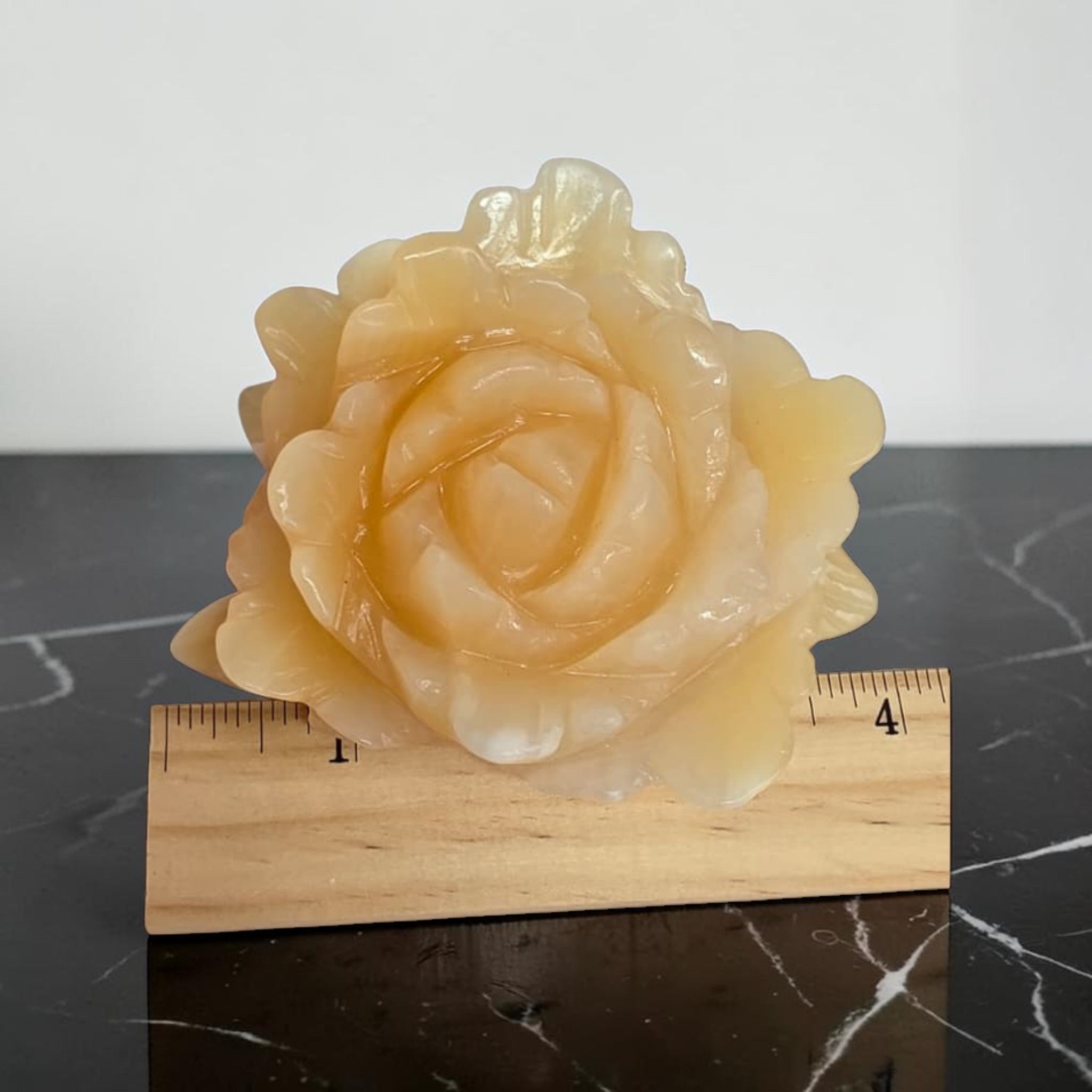Yellow calcite rose carving top view showing layered petal detail on marble surface